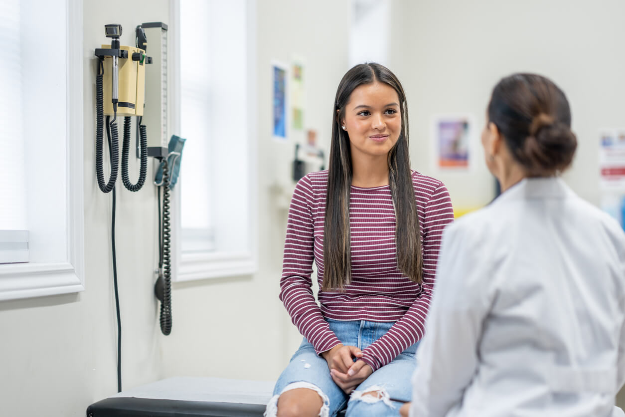 Young teen with doctor to promote healthy habits and regular check ups.