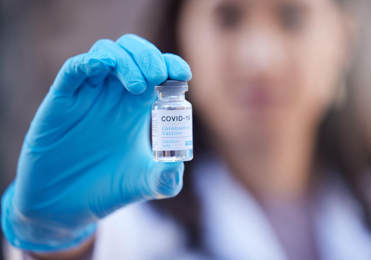 Defocused shot of an unrecognizable doctor wearing gloves and holding a corona virus covid-19 vaccine